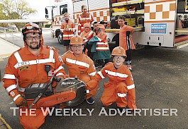 PROUD: Horsham SES members Jarrod McLean and Charlotte Downs visited Horsham Primary School Rasmussen Campus to promote Wear Orange Wednesday. Mr McLean shows his own children Eli and Zahlee a mobile cutter used for rescues. Picture: PAUL CARRACHER