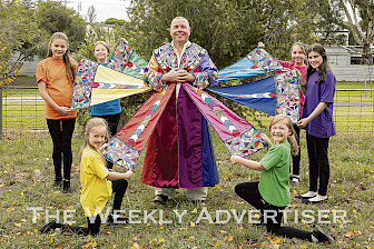 COLOURFUL: Scott Rigby as Joseph shows off his coat, flanked by the children’s chorus, clockwise from front left, Makayla Fell, Olive Kerr, Shania Atkins, Hope Brew, Sophie Fletcher and Danae Atkins.