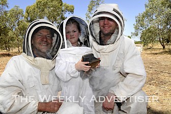 BUSY BEES: From left, Andrew, Lucy, 5, and Greg Mathews check the bees at Grampians Olive Co. Pictures: PAUL CARRACHER