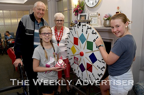 Bert Haustorfer and Owna Tegelhuterbuy spinning wheel tickets off Eden Labram and Abbey O'Connor at a CFA fundraiser at Sunnyside Lutheran Retirement Village.