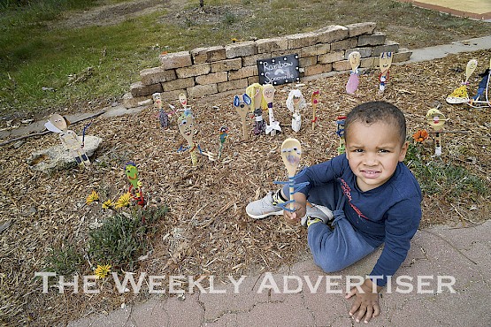 Eli Simpson, 3, adds his spoon to Rainbow Spoonville at The Oasis Rainbow. School teacher Stephanie Newton said teachers sent packs home for school children to make spoons as a community initiative during COVID-19.