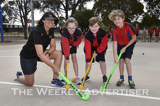 Horsham Hockey Club member Sue Roberts shows Horsham Primary School students Holly Potter, Tom Klitscher and Ollie Watson hockey techniques at a clinic.